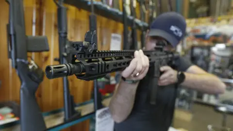 George Frey Dordon Brack, aims a semi-automatic AR-15 that is for sale at Good Guys Guns & Range on February 15, 2018 in Orem, Utah.