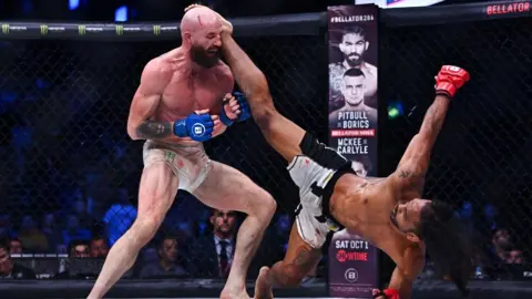 Benson Henderson aims a head kick at Peter Queally