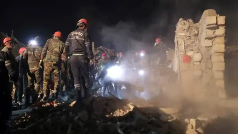 EPA Rescue workers at the scene of damage in the Azerbaijani city of Ganja