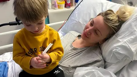 Sadie Kemp in hospital bed with one of her children