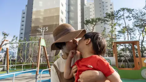 Jean Chung Jungyeon and her child at a playrgound