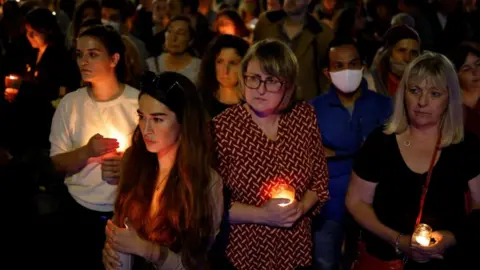 Getty Images Women hold lighted candles during a vigil for 28 year-old teacher Sabina Nessa
