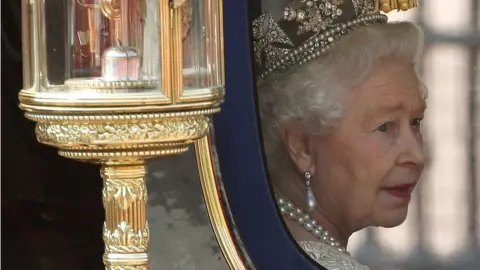 PA / Dominic Lipinski Queen Elizabeth II looking out the window of her carriage after the State Opening of Parliament