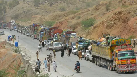 AFP A line of vehicles are pictured as Pakistani civilians, fleeing a military operation in North Waziristan, wait to cross a checkpoint at the Bannu Frontier Region registration centre for internally displaced people in Saidgai on 22 June 2014