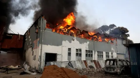 EPA A business is set on fire during widespread looting and protests in Durban, South Africa - 12 July 2021