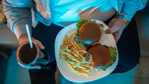 Getty Images Obese man with unhealthy food