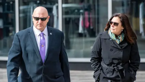 Getty Images Jack Teixeira's stepfather Thomas Dufault and mother Dawn Dufault walk outside a court house