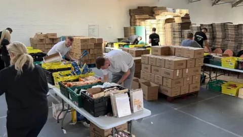 Feeding families Volunteers packing boxes of food