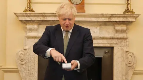 Andrew Parsons / No 10 Downing Street Boris Johnson using a PAX payment terminal