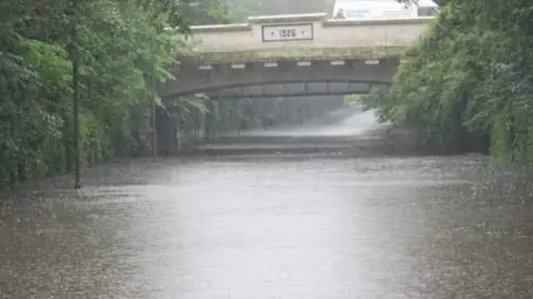 Lorraine Waters Floodwater in road under a bridge