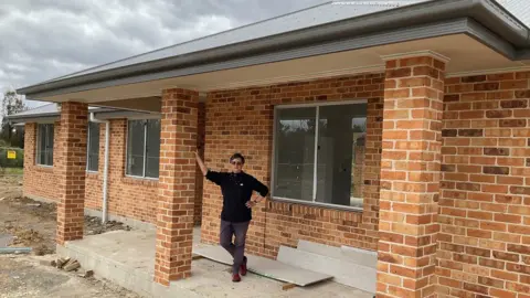 Elizabeth Atkin Elizabeth Atkin standing in front of her partially rebuilt house