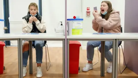 PA Media Students Ellie Fisher (left) and Beth Hicks (right) take Coronavirus lateral flow tests at Outwood Academy Adwick in Doncaster, ahead of schools and colleges fully reopening on Monday