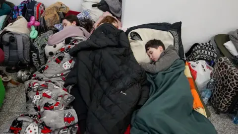 Getty Images Ukrainian refugees rest at Krakow railway station