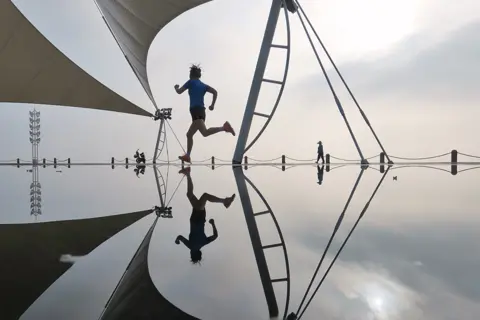 Tang Ke / Getty Images A person exercises in Yantai, Shandong Province of China, on 29 June 2022