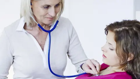 Science Photo Library A GP listening to a patient's heart