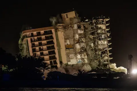 Giorgio Viera / AFP A controlled explosion brings down the remains of the Champlain Towers South apartment block in Surfside, Florida on 4 July 2021