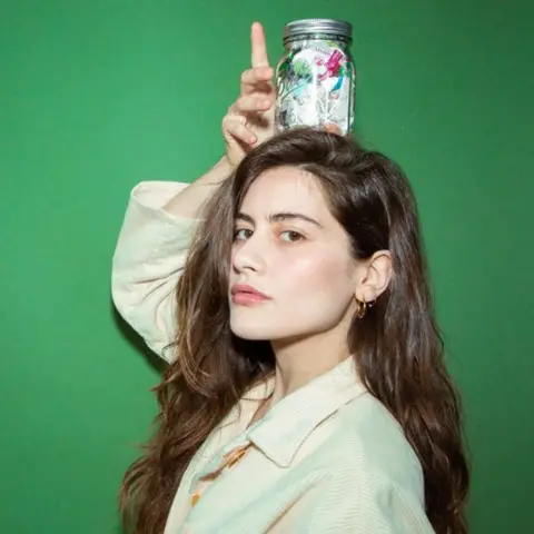 Lauren Singer Lauren singer with her jar of waste on her head