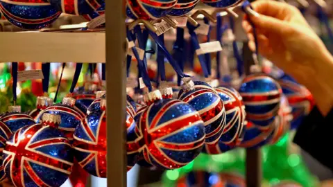 Getty Images A customer looks at Union Jack decorated Christmas tree baubles in a John Lewis department store