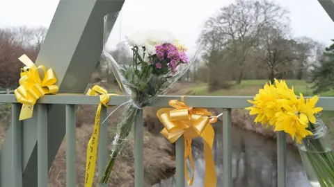 PA Media Flowers, and ribbons on a bridge over the River Wyre