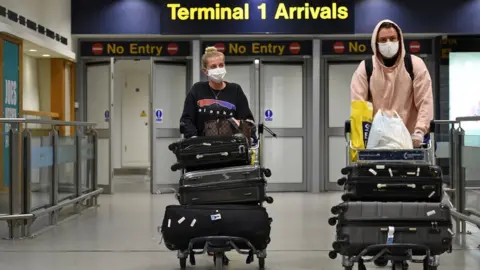 AFP/Getty Images Passengers arrive at Manchester Airport