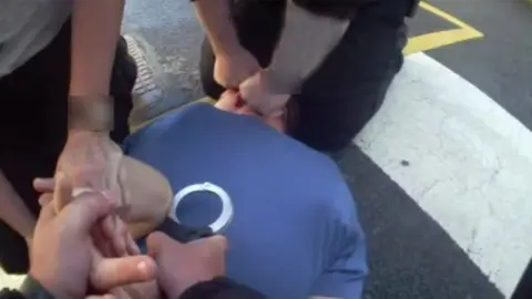 Ministry of Justice Michael Smith being restrained