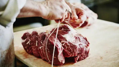 Getty Images Beef joint being prepared by a butcher