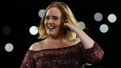 Getty Images Adele smiling on stage