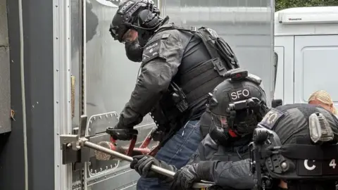 Firearms Officers breaking open a lorry housing a suspected cannabis plant nursery in St Leonards