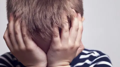 Getty Images Boy with head in hands