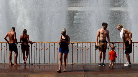 Reuters People cool off at a fountain in Battersea Park