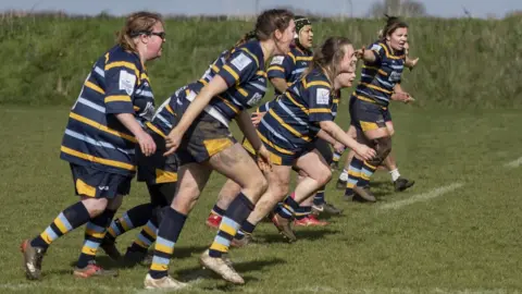 Trowbridge RFC A group of muddy women playing rugby