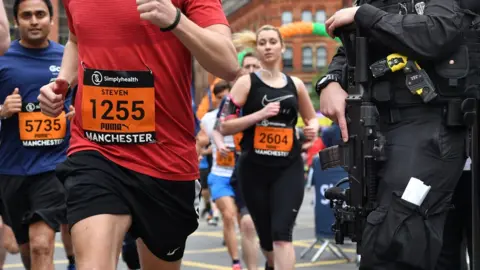 Getty Images Armed police watch over runners close to the starting line during the Simplyhealth Great Manchester Run