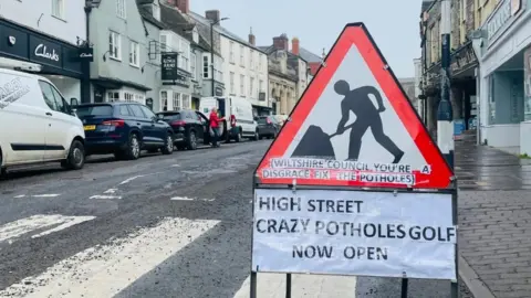 Ben Thornbury Pothole sign on pedestrian crossing