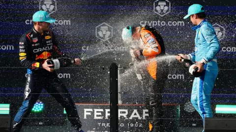USA Today Sports Drivers spray each other from bottles on a podium