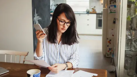 Getty Images Young woman with bills