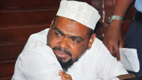 AFP Muslim cleric Aboud Rogo Mohammed sits in the Mombasa Law courts on January 30, 2012 after being charged with possession of dangerous weapons, an AK 47 rifle, 133 rounds of ammunitions, two hand grenades, and two pistols.
