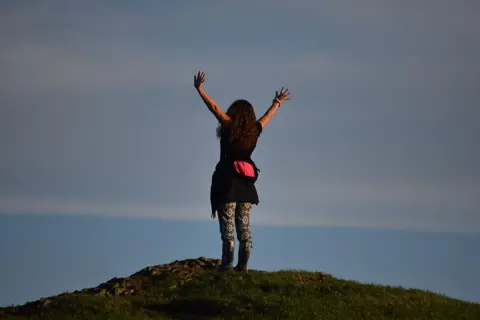 Bonnie Woman at the top of a hill