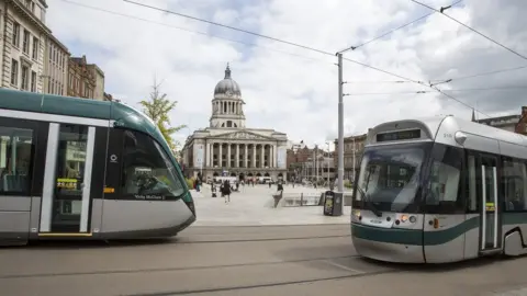 Getty Images Two trams pass each other in front of the central square in front of Nottingham's town hall