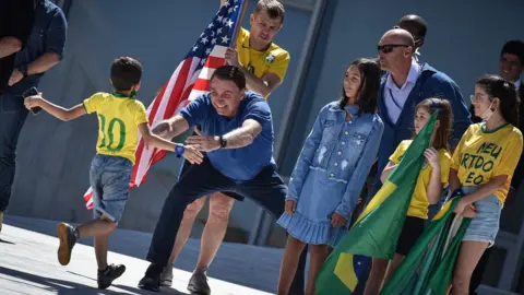 Getty Images Brazil's President Jair Bolsonaro meets supporters during a protest in favour of the government and against the lockdown