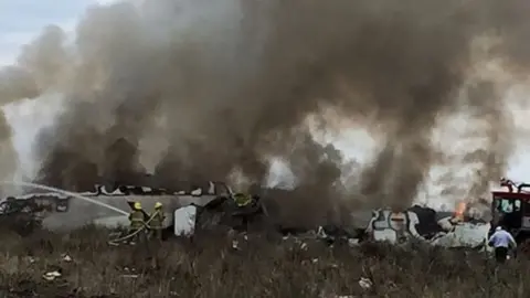 EPA A handout photo made available by the Civil Protection State Coordination (CPCE) shows emergency personnel at the site where an Aeromexico plane crashed, in Durango, Mexico, 31 July 2018.