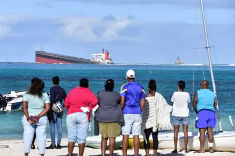 AFP People on shore look out at the MV Wakashio on 6 August 2020.