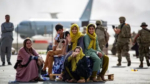 US Marine Corps/Reuters Afghans wave as they wait to board evacuation flights in Kabul