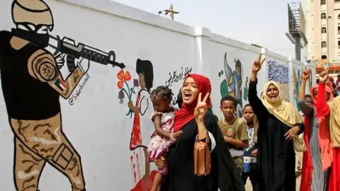 AFP Demonstrators celebrate in Khartoum after a military rulers and protest leaders signed a constitutional declaration paving the way for a transition deal, 4 August