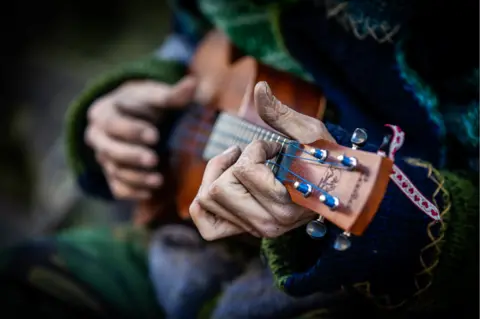 Stewart playing his ukulele