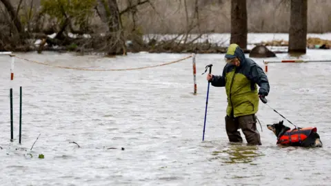 Reuters A woman walks through floods
