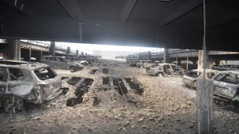 Merseyside Fire and Rescue/Reuters Burned out cars