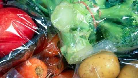 Science Photo Library Vegetables individually wrapped in cellophane