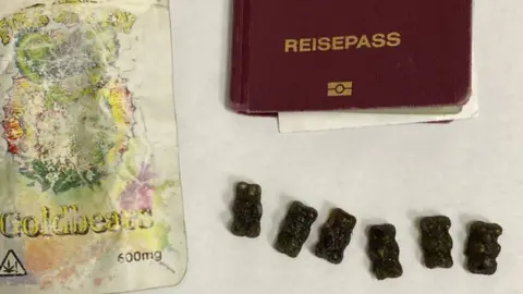The gummy bears packaging, six gummy bears and a German passport