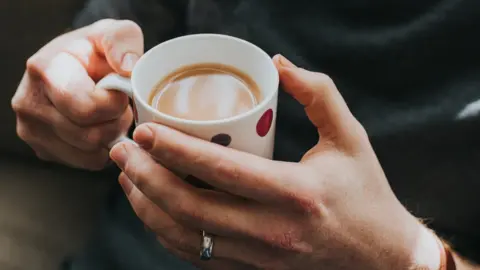 Getty Images Hands holding mug