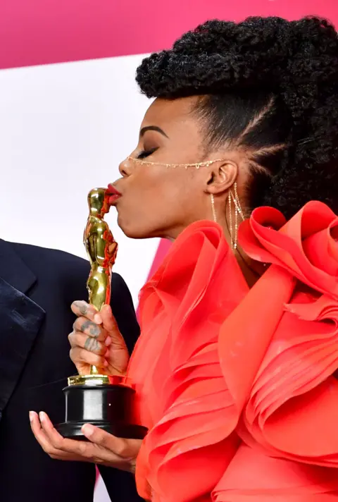 Getty Images Hannah Beachler kissing her Oscar award